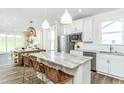 Bright kitchen with an island, stainless steel appliances, white cabinets, and plenty of natural light at 1622 Garden Park Cir, Fuquay Varina, NC 27526