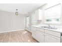 Eat-in kitchen with laminate floors, bright windows, and white cabinets and countertops at 1628 Briarmont Court Ct, Raleigh, NC 27610