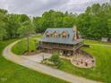 Secluded multi-story home with wrap-around porch and stone chimney nestled on large landscaped lot at 169 Country Brooke Lane Ln, Roxboro, NC 27574