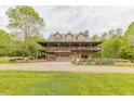 Beautiful two-story stone home with a metal roof, surrounded by lush greenery and a well-manicured lawn at 169 Country Brooke Lane Ln, Roxboro, NC 27574