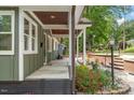 Inviting covered front porch with brick accents and beautifully landscaped garden beds at 2114 Woodview Dr, Raleigh, NC 27604