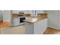Bright kitchen with wood countertops, white cabinetry, modern appliances, and a cozy breakfast bar at 213 Old Mallard Rd, Smithfield, NC 27577