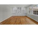 Spacious room featuring hardwood floors, a large window, and custom built-in shelving with cabinetry at 213 Old Mallard Rd, Smithfield, NC 27577