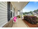 Inviting front porch with white bench, colorful pillows, and manicured landscaping at 233 Berg St, Smithfield, NC 27577