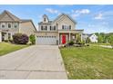 Traditional two-story house featuring neutral siding, a red door, and a nicely maintained front lawn at 2429 Follow Me Way, Raleigh, NC 27610