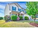 Beautiful two-story home with flowering bushes and a lush lawn beneath a mature tree at 2540 Averon Dr, Fuquay Varina, NC 27526