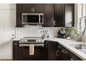 Modern kitchen featuring stainless steel appliances, white countertops, and dark cabinetry at 2702 Richwood Rd, Durham, NC 27705