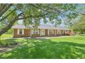A single story home with brick facade, white trim, and a large, lush green lawn at 3011 Old Hillsborough Rd, Mebane, NC 27302