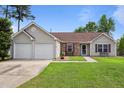 Charming single-story home featuring a well-manicured lawn, two-car garage, and lovely facade at 308 Holly Briar Dr, Fuquay Varina, NC 27526