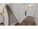 Warm and welcoming entryway with hardwood floors and a staircase to the upper level at 316 Barley Mill Rd, Holly Springs, NC 27540