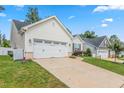 View of the house with a two-car garage, long driveway and well-maintained greenery at 3248 Castlerock Dr, Burlington, NC 27215