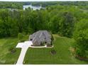 Stunning aerial view of a home with beautiful landscaping and a lake in the distance at 325 Forest Bridge Rd, Youngsville, NC 27596