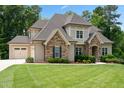 Charming home featuring stone accents, a manicured lawn, and attached garage at 325 Forest Bridge Rd, Youngsville, NC 27596