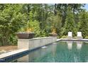 Tranquil pool featuring stone accents, fire bowls, and poolside seating at 325 Forest Bridge Rd, Youngsville, NC 27596