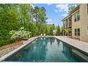 Resort-style pool with lush landscaping, outdoor seating, and a private screened-in back porch at 325 Forest Bridge Rd, Youngsville, NC 27596