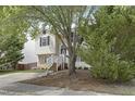 Charming home with stone accents and white siding partially obstructed by trees at 3613 Ranbir Dr, Durham, NC 27713