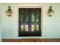 Inviting front entryway with black double doors, decorative lanterns, and brick flooring at 3804 Nottaway Rd, Durham, NC 27707