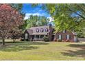 Charming brick home featuring a covered porch, dormer windows, and a well-maintained lawn at 3909 Inland Ct, Raleigh, NC 27606