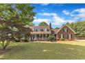 Charming brick home featuring a covered porch,dormer windows, and mature trees at 3909 Inland Ct, Raleigh, NC 27606