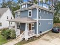 This two-story home has blue siding, a covered porch, and a driveway with parking at 408 Jerome Rd, Durham, NC 27713
