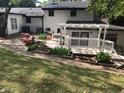 A lush backyard featuring a white pergola, manicured landscaping, and a well-maintained lawn at 5002 Wickham Rd, Raleigh, NC 27606