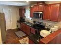 Features a well-equipped kitchen with granite countertops, dark wood cabinets and stainless steel appliances at 5002 Wickham Rd, Raleigh, NC 27606