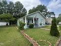 Quaint home featuring a well-manicured lawn and a charming front porch with ample greenery at 514 E Lee St, Smithfield, NC 27577