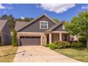 Charming home exterior with stone and siding, featuring a well-maintained lawn and mature landscaping at 5144 Niagra Dr, Chapel Hill, NC 27517