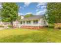 Cozy single-story home with a charming front porch, green lawn, and mature trees at 5317 Cottage Bluff Ln, Knightdale, NC 27545