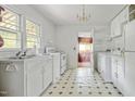 White kitchen features a classic design with vintage tile flooring and ample natural light at 5743 Craig Rd, Durham, NC 27712