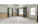 Bright living room featuring vintage wallpaper, large windows, and a ceiling fan at 5743 Craig Rd, Durham, NC 27712