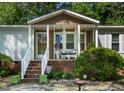Close-up of the charming front porch with brick stairs and decorative plants at 6237 Nc 96 Hwy W, Youngsville, NC 27596