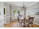 Dining room features hardwood floors, a decorative chandelier, and a large window at 7019 Bellard Ct, Raleigh, NC 27617