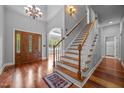 Inviting foyer featuring a wooden front door, staircase with white railings, and hardwood floors, with lots of natural light at 7212 Donneeford Rd, Wake Forest, NC 27587