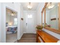 Inviting foyer with wood floors, a decorative mirror, and a glimpse into a cozy bedroom at 73 Windswept Way, Fuquay Varina, NC 27526