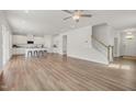 Bright living room featuring an open floor plan, hardwood floors and staircase leading to upper level at 73 Windswept Way, Fuquay Varina, NC 27526