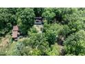 Aerial view of wooded property featuring house, detached garage, and in-ground trampoline at 82 Deercorn Path, Moncure, NC 27559