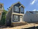 Exterior view of a two-story home featuring gray siding, white trim and ample window light at 903 Linwood Ave, Durham, NC 27701