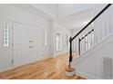 Bright foyer with hardwood floors, white walls, staircase with black railing, and natural light at 9117 Meadow Mist Ct, Raleigh, NC 27617