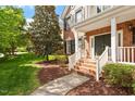 Inviting front porch with brick steps, white railings, and a well-manicured landscape leading to the entrance at 9117 Meadow Mist Ct, Raleigh, NC 27617