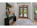 Inviting foyer featuring modern artwork, stylish decor, and beautiful wood double doors at 949 Harrison Ridge Rd, Wake Forest, NC 27587
