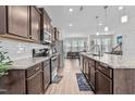 Open-concept kitchen boasts granite countertops, stainless steel appliances, wood cabinets, and subway tile backsplash at 987 Parkstone Towne Blvd, Knightdale, NC 27545