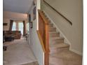 Living area featuring carpeted staircase, and a glimpse of the backyard at 10 Grove Park Rd, Durham, NC 27705