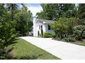 A long driveway leads to a well-maintained home surrounded by lush greenery at 1004 Greenwich St, Raleigh, NC 27610