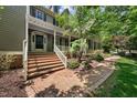 Charming two-story home with a covered front porch and brick steps leading up to the front entrance at 101 Abbotsford Ct, Durham, NC 27712