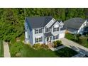 Aerial view of a two story home with gray siding, black shutters, green lawn and mature trees at 101 Worsham Dr, Chapel Hill, NC 27516