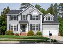Beautiful two-story home with grey siding, black shutters, manicured lawn and attached garage at 101 Worsham Dr, Chapel Hill, NC 27516