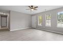 Bright, neutral living room featuring wood-look floors and multiple windows for ample natural light at 1100 Pecan Pl, Durham, NC 27704