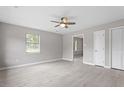 Bright living room featuring stylish light gray walls, wood-look floors, and a modern ceiling fan at 1100 Pecan Pl, Durham, NC 27704