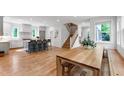 Open-concept living space with hardwood floors, a large island, and a staircase leading to the upper level at 112 Meadowbrook Dr, Chapel Hill, NC 27514